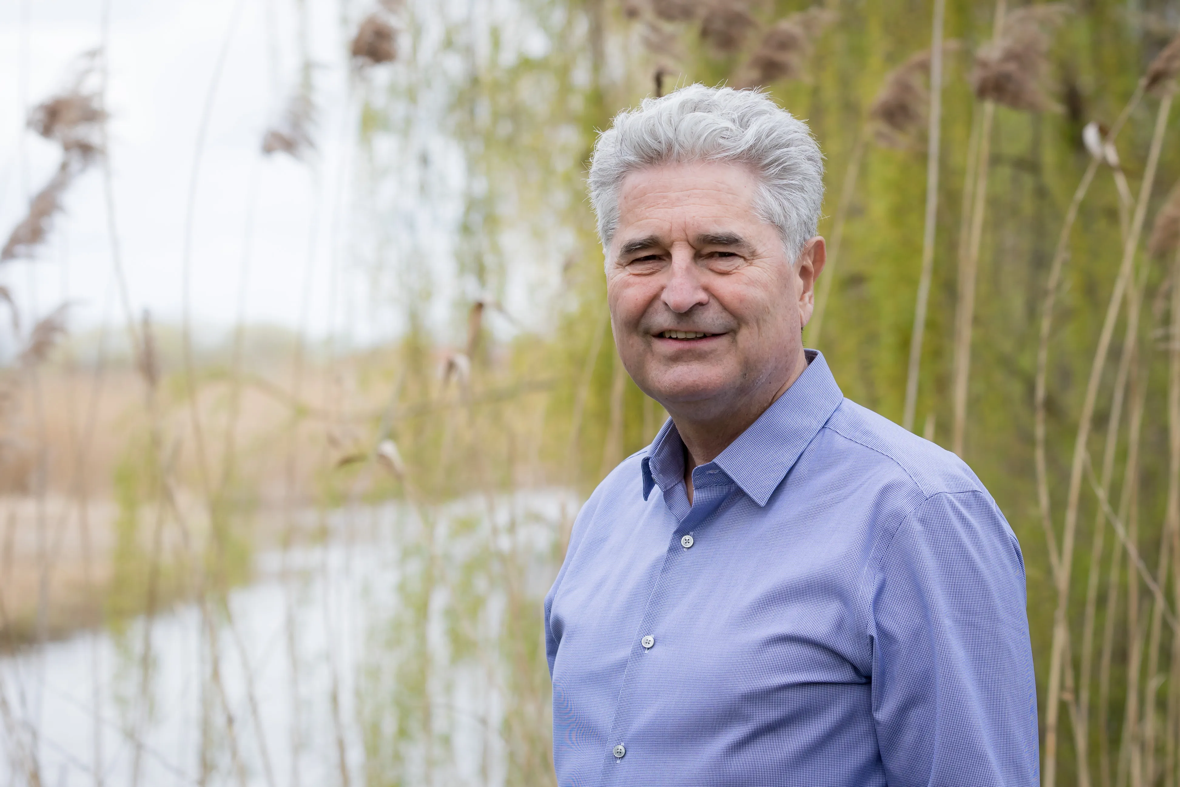 Portrætbillede af Thomas Lisbjerg-Jensen ved Furesøen, med siv og vand i baggrunden